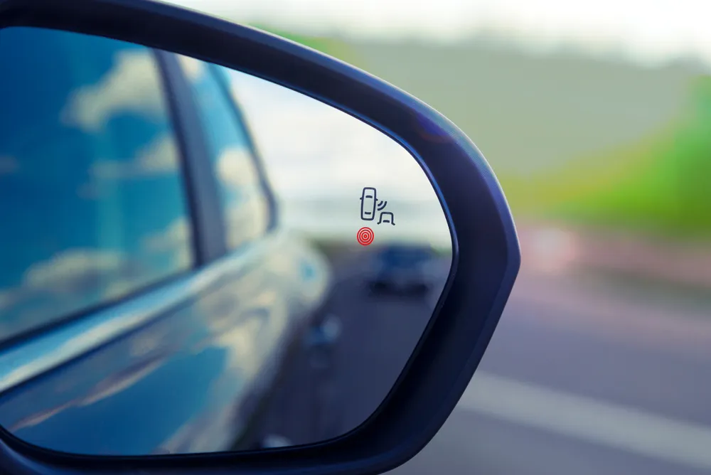 blind zone monitoring sensor on the side mirror of a modern car.